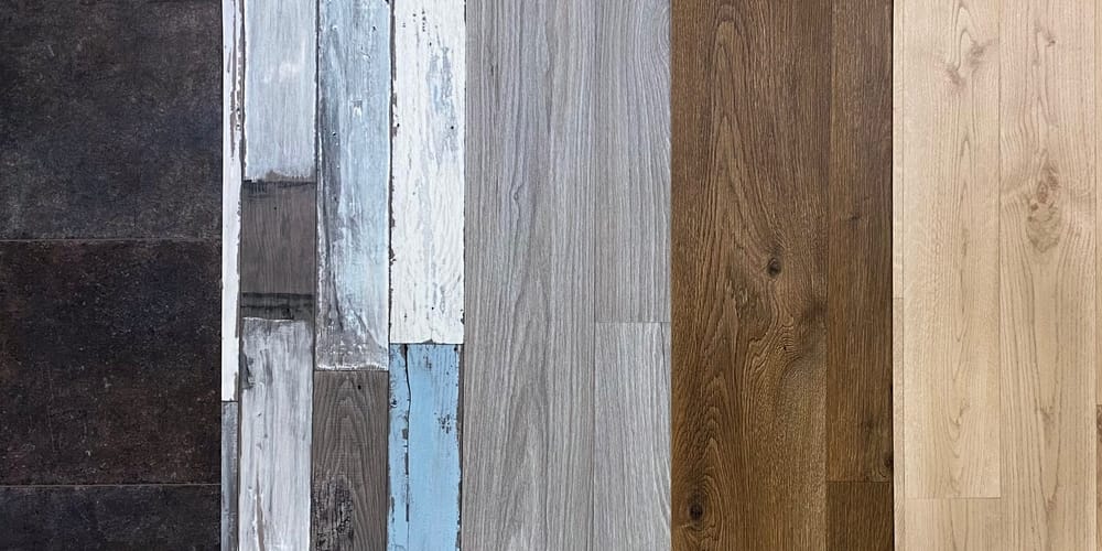 Five varieties of sheet vinyl: a dark tile pattern, a distressed painted wood-plank look, and three natural wood textures.