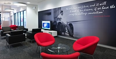 A modern commercial meeting space, with red and black arm chairs atop Savvy carpet tiles.